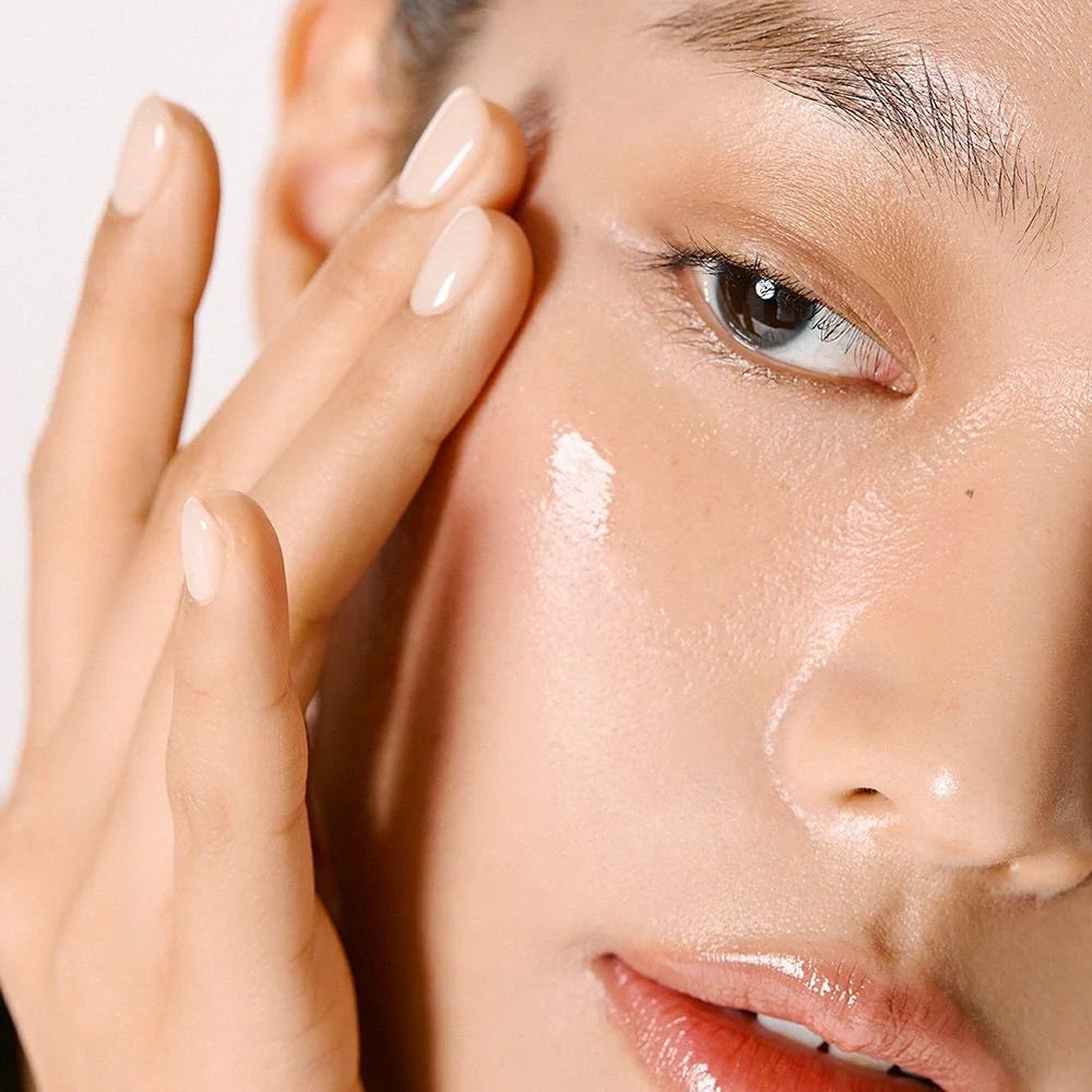 Finger påfører Anua Niacinamide 10% + TXA 4% Dark Spot Correcting Serum 30ml på glat, fugtet kind.