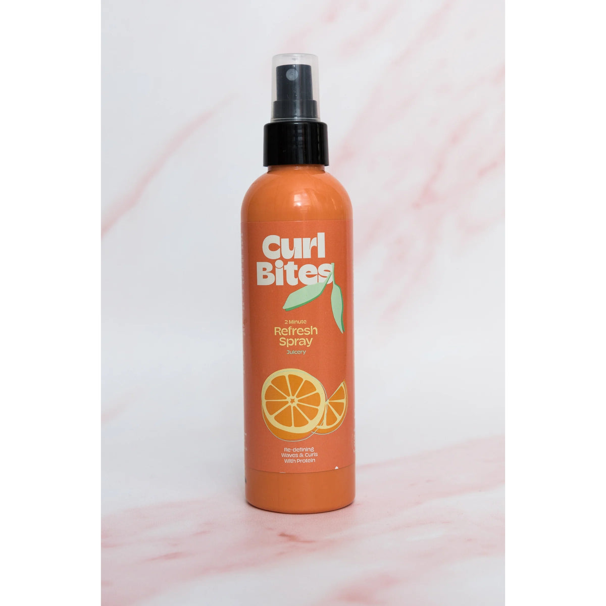 Curl Bites 2 Minute Refresh Spray, orange sprayflaske med appelsinmotiv og sort pumpehoved.