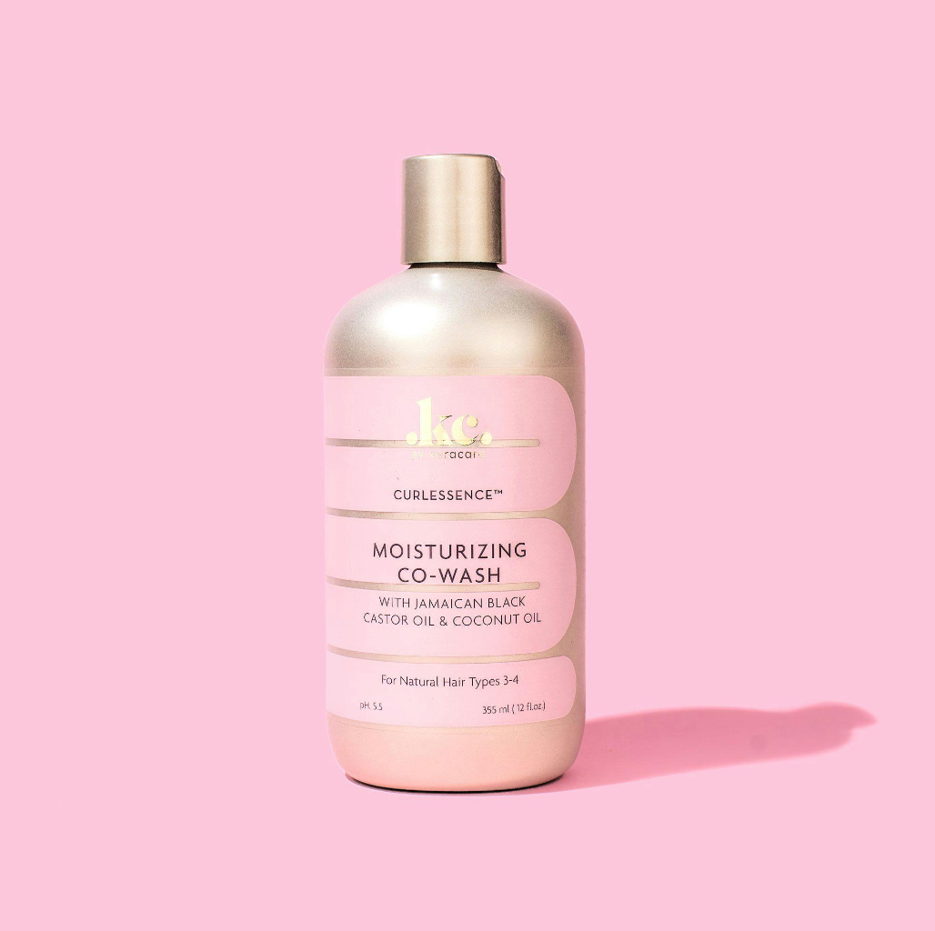 KeraCare Curlessence Moisturizing Co-Wash 355ml i lyserød flaske med guldlåg mod rosa baggrund.