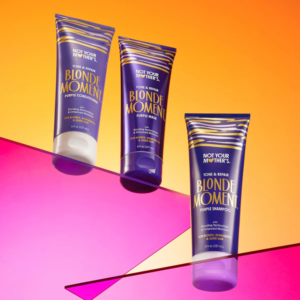 Not Your Mother's Blonde Moment Purple lilla shampoo, conditioner og hårmaske mod orange og pink baggrund.