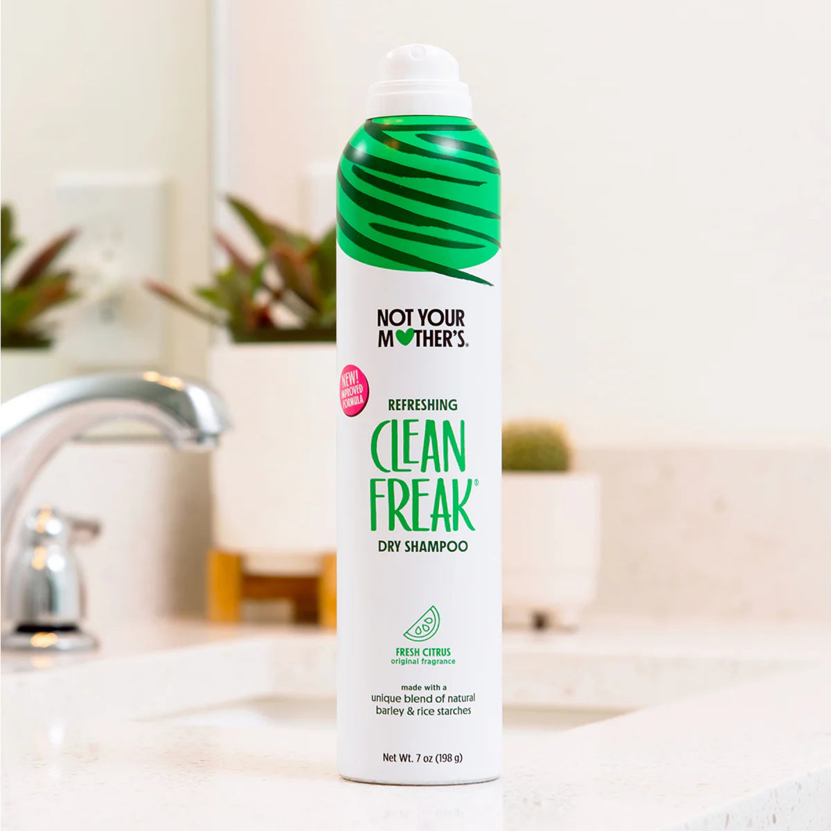 Not Your Mother's Clean Freak tørshampoo i fresh citrus duft stående på badeværelsesvask med grøn og hvid emballage.