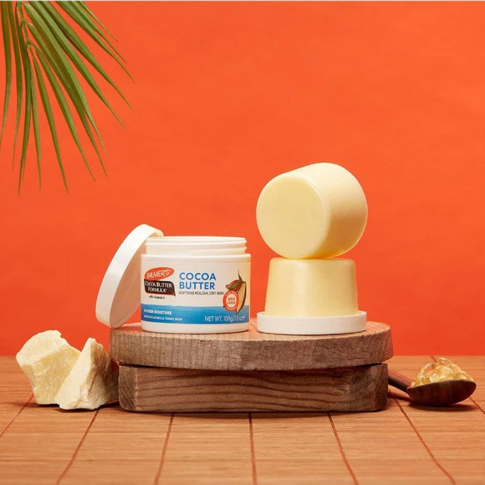 Palmers Cocoa Butter Formula Cream (100g) krukke vist med kakaosmør i fast form og smeltet form.