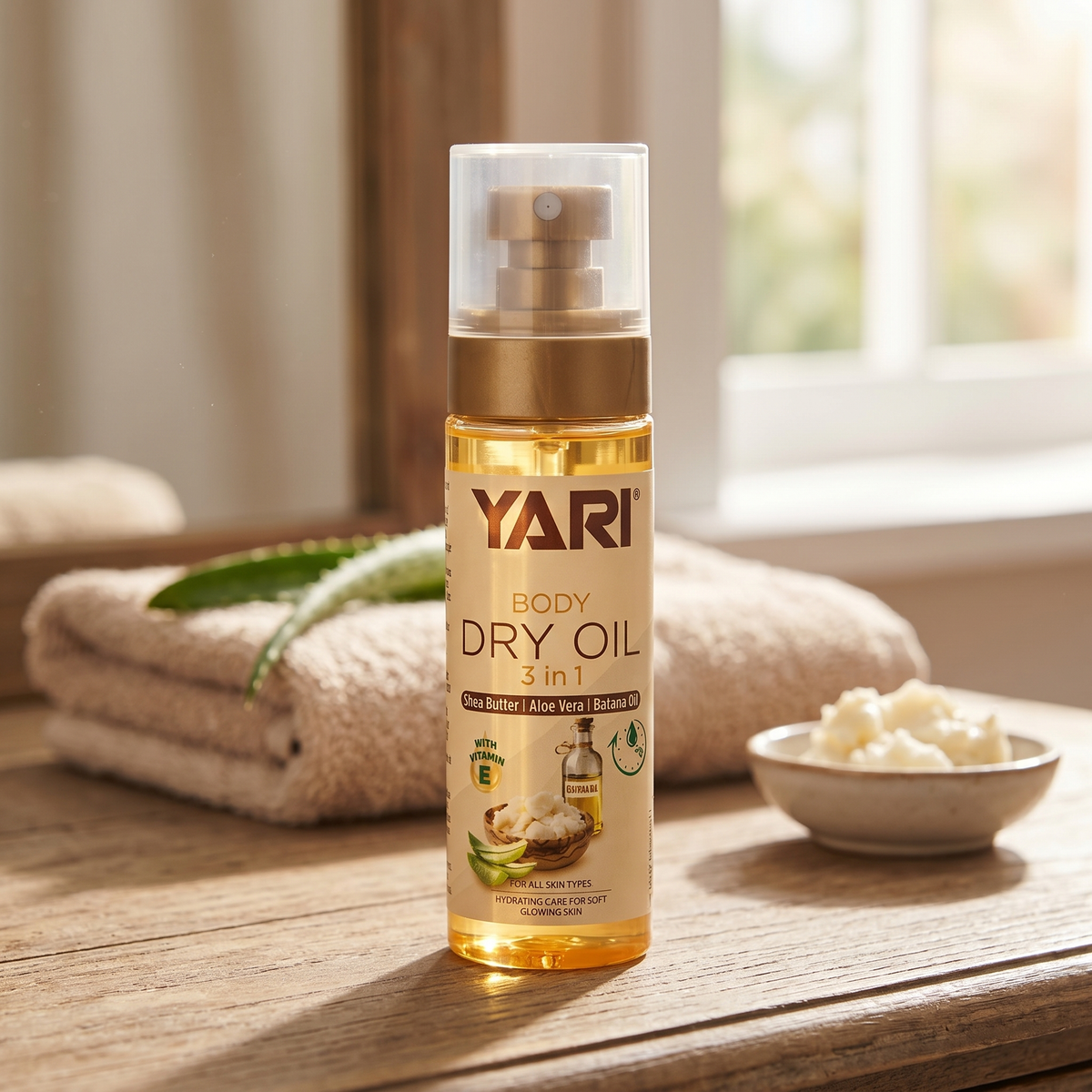 Yari Body Dry Oil 3 in 1 med shea butter og aloe vera på træbord ved håndklæde og vindue.